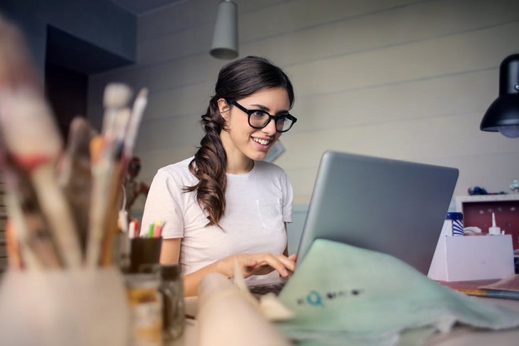 A young and focused businesswoman working on a laptop at a table in her office