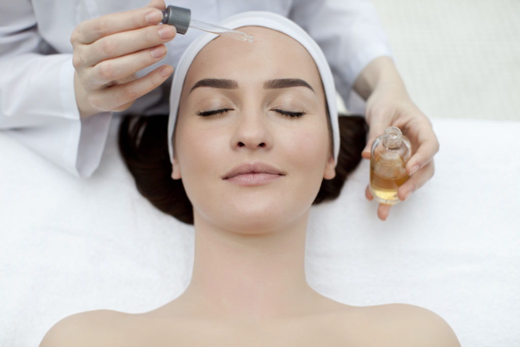 Esthetician applying skincare products.