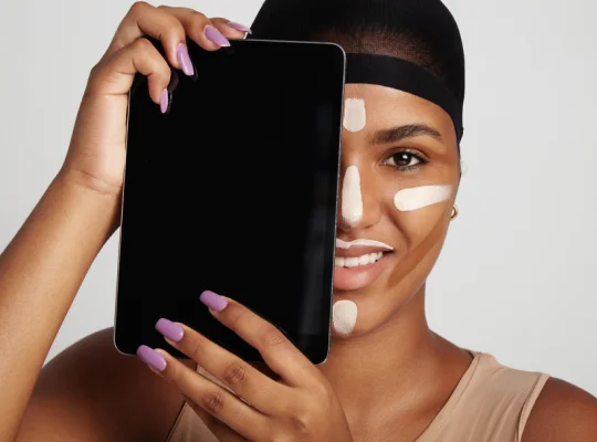 A model with a tablet partially covering her face, striking a unique and modern pose