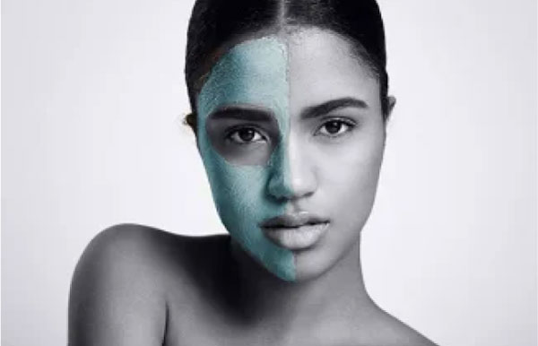 A model showcasing a half-applied beauty mask, demonstrating skincare and self-care routine