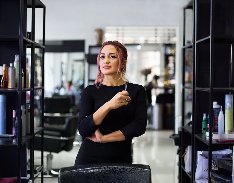 image of Cosmetology student standing on the salon floow