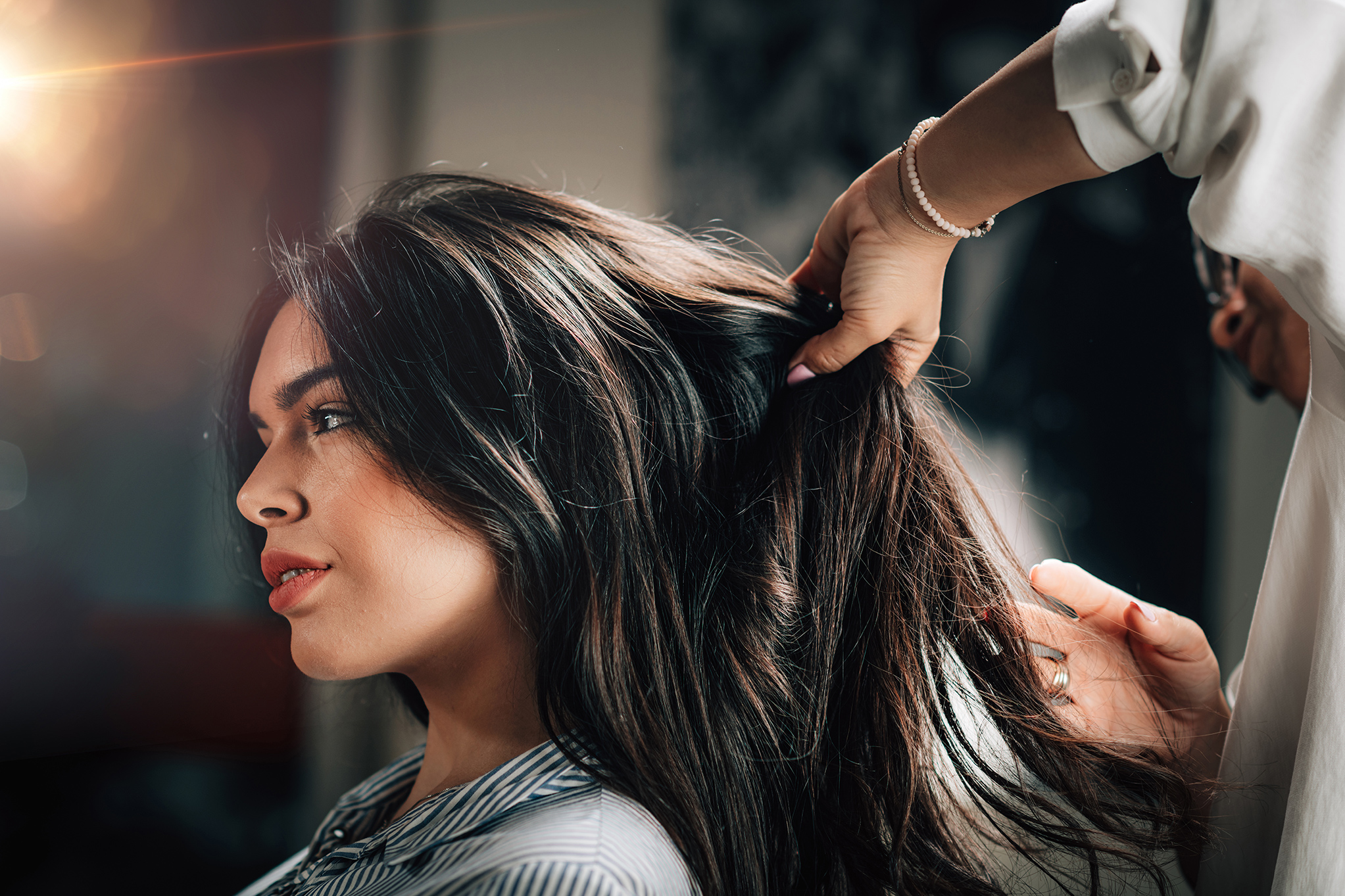 A young and beautiful woman getting a new hairstyle with the skilled hands of a stylist