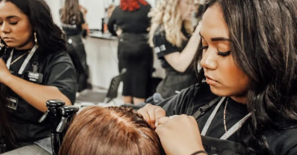 cosmetology school applies braids to mannequin