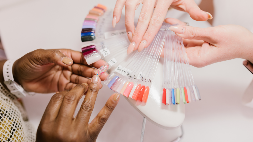 Nail tech showing a customer a pallet of different finger nail options