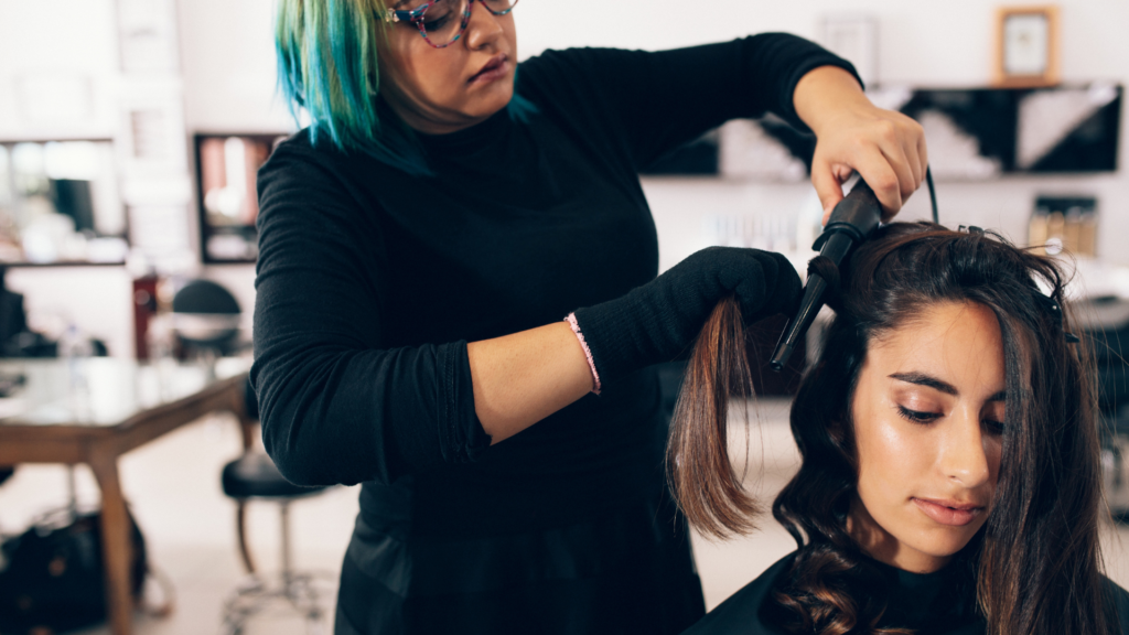 picture of Hairstylist applying wand curls to clients hair