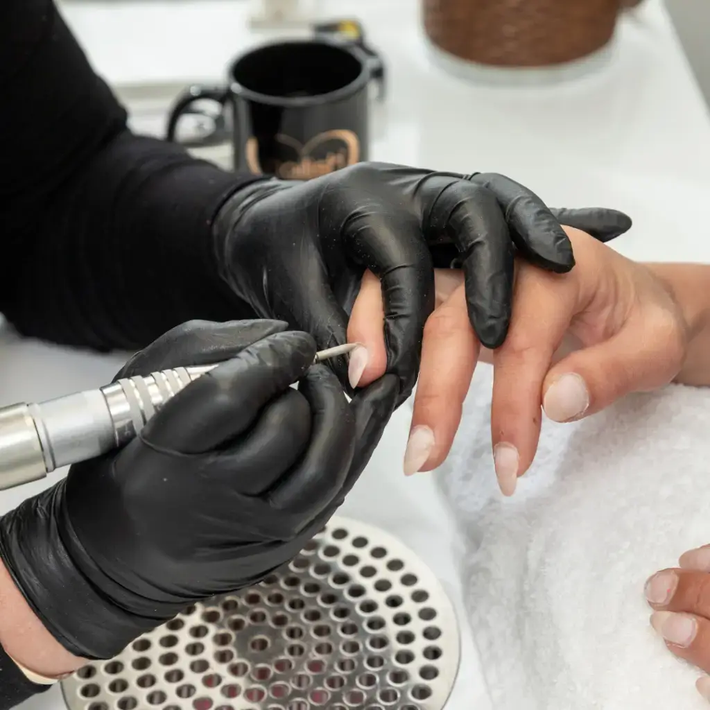 Nail tech performing nail service at beauty school