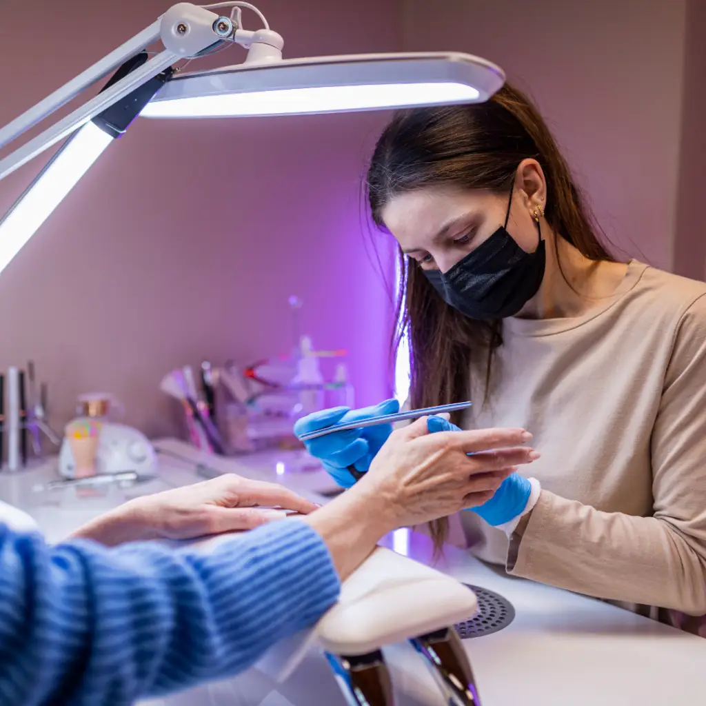 Nail tech performing nail service at nail tech training school