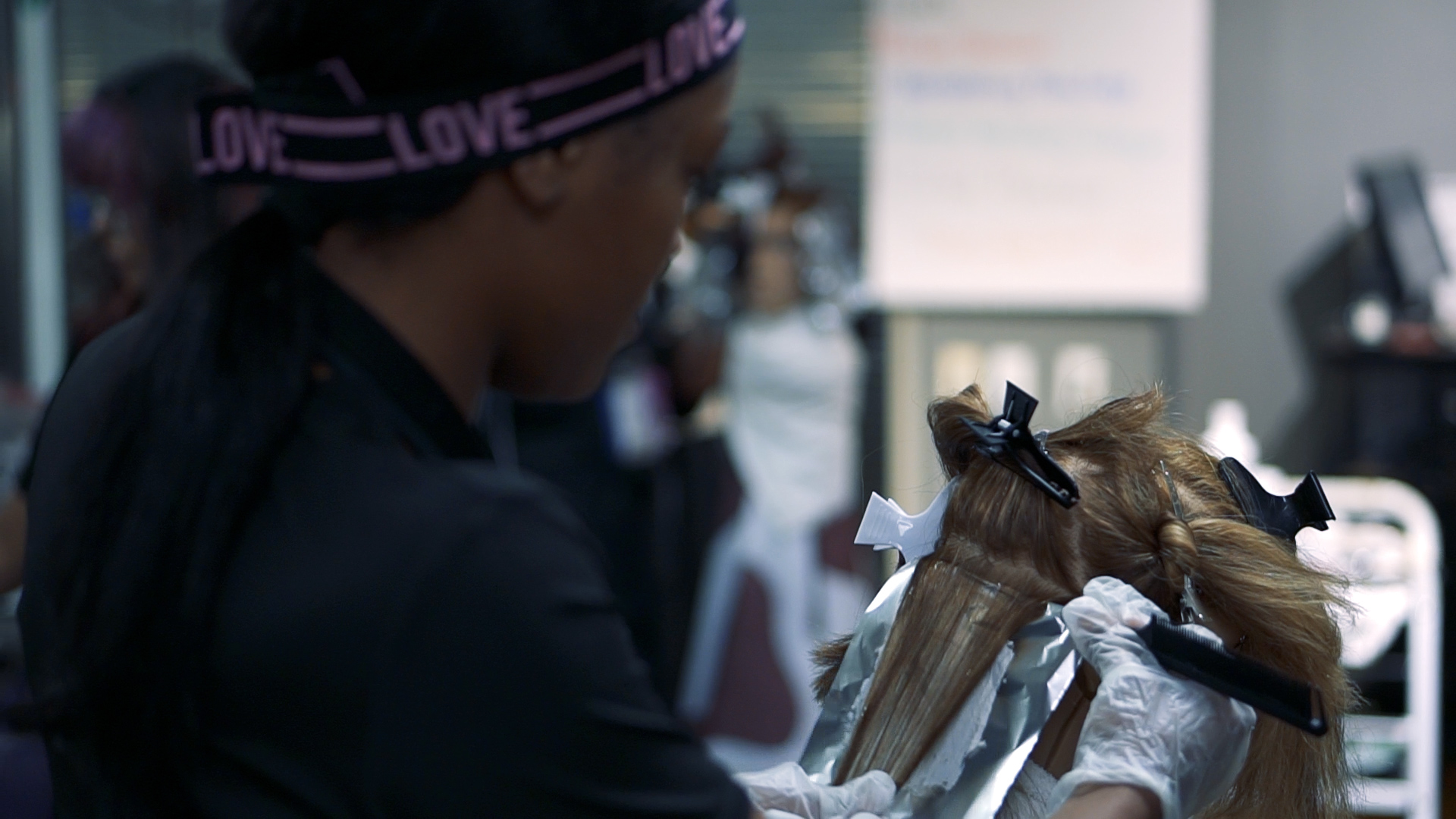 Ogle school cosmetology student performing hair care