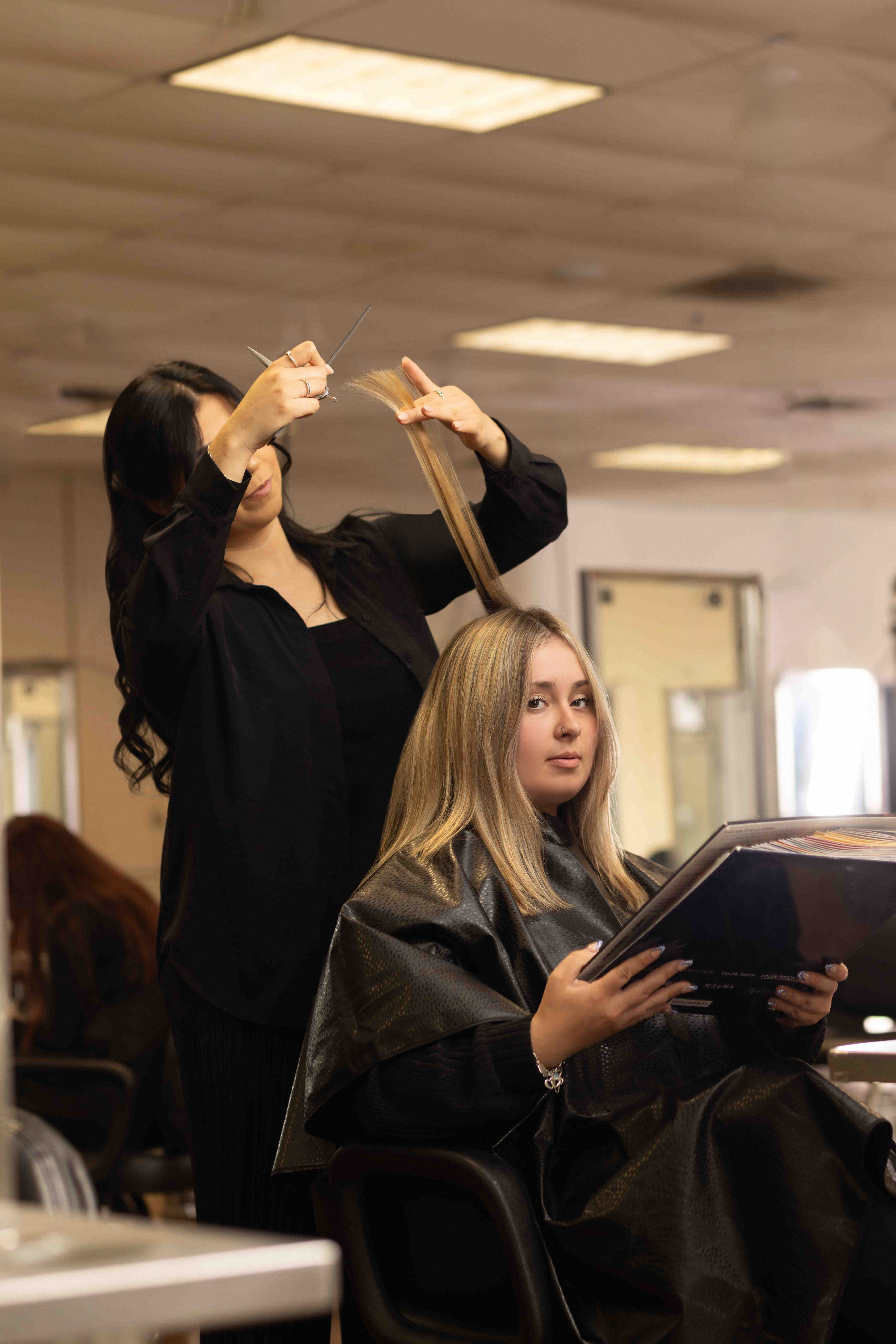 8B9A2288 Ogle School cosmetology student performing hair styling technique on a client