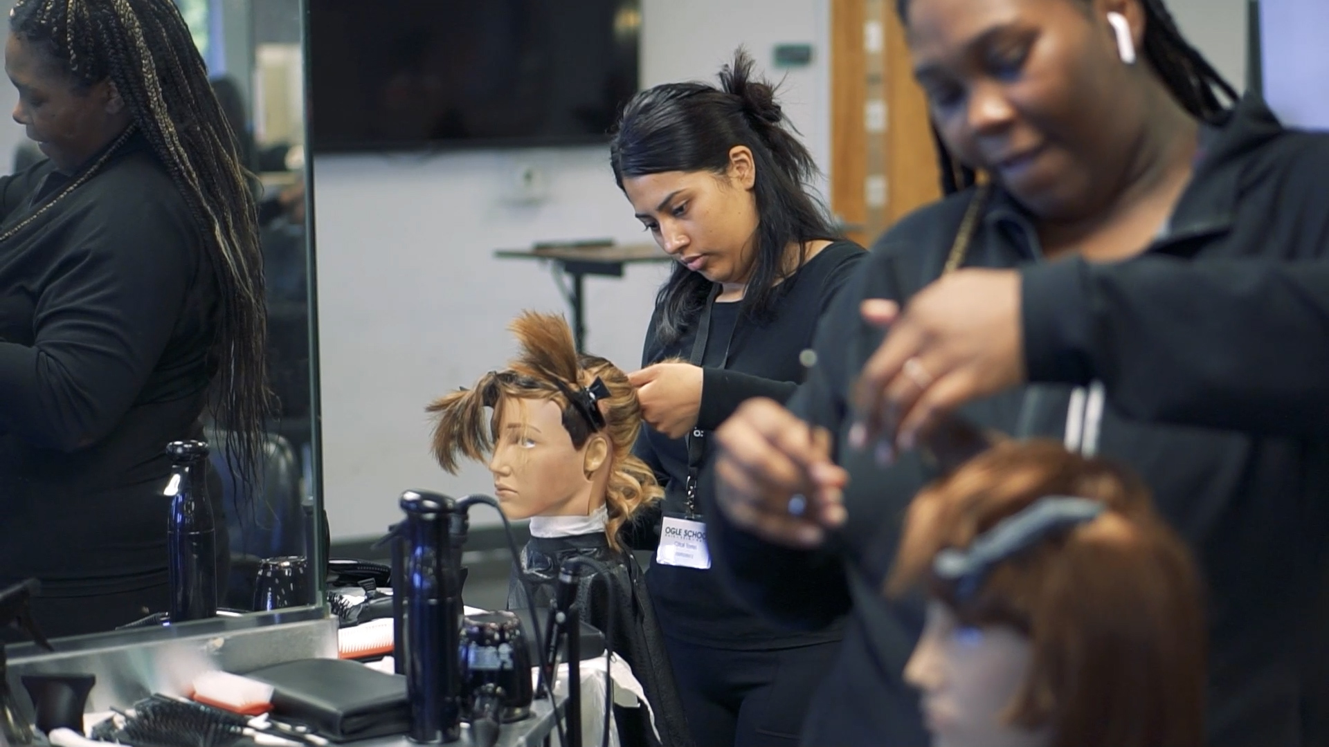 Ogle school cosmetology student in Houston working on her hair styling