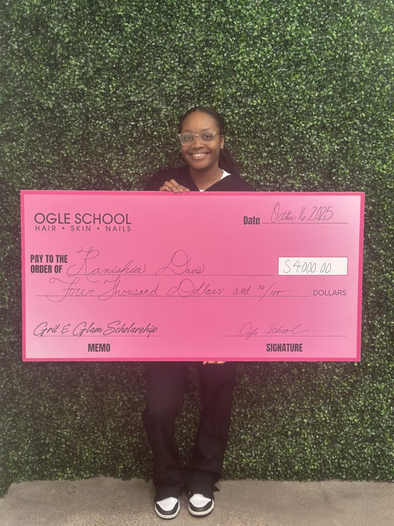 Image of ogle school student receiving a big check for the $4,000 Grit and Glam Scholarship