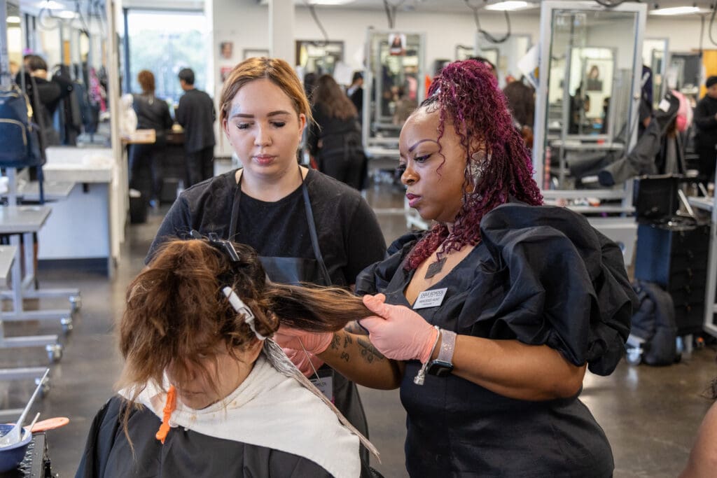 Image of ogle school student practicing hair techniques with an expert instructor