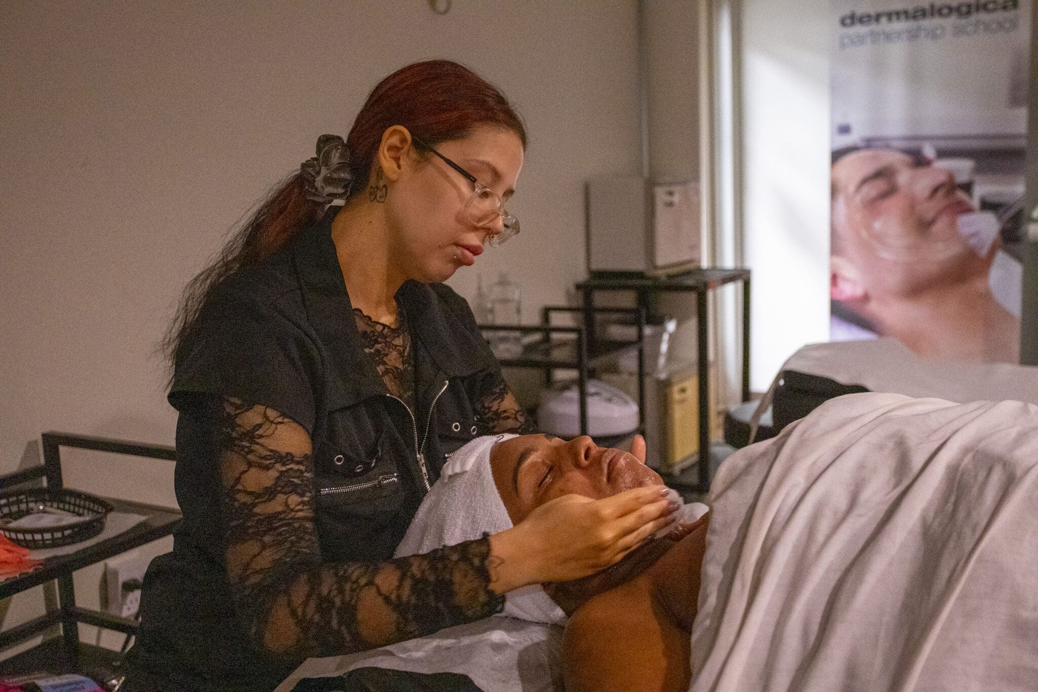ogle school student giving a facial to a client