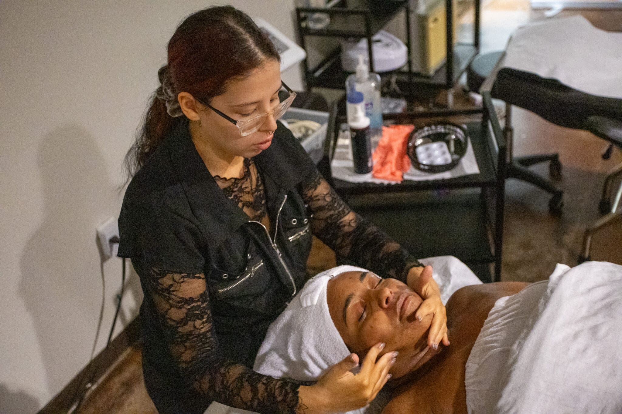 ogle school student giving a facial to a client