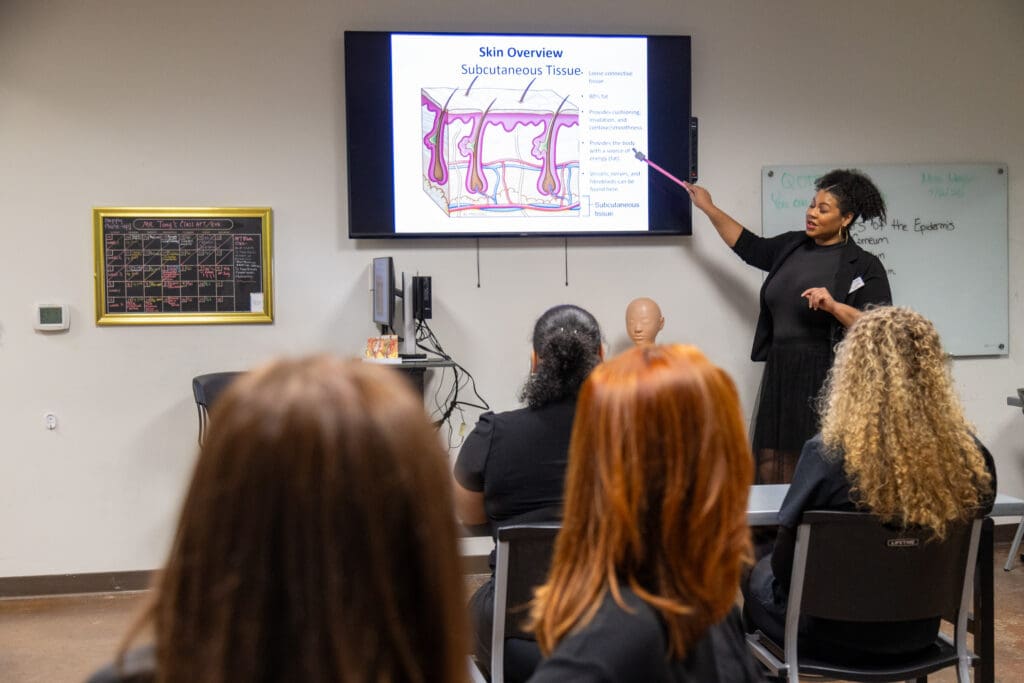 Ogle school instructor training students on waxing and facials