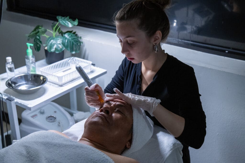Ogle school esthetics student performing a facial on a client