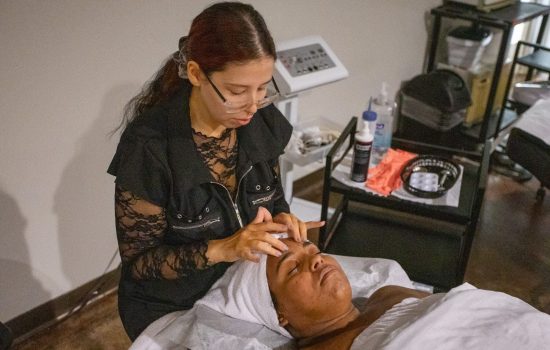 ogle school student giving a facial to a client