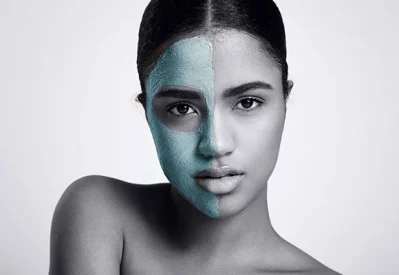 A model showcasing a half-applied beauty mask, demonstrating skincare and self-care routine